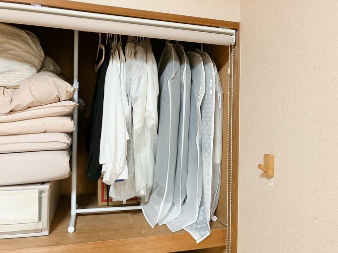 洋服を押し入れ内のつっぱり棒にハンガーでかけている図