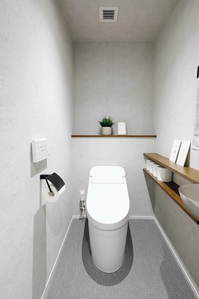 床をサイザル麻のようなテクスチャーのタイルで仕上げたトイレ