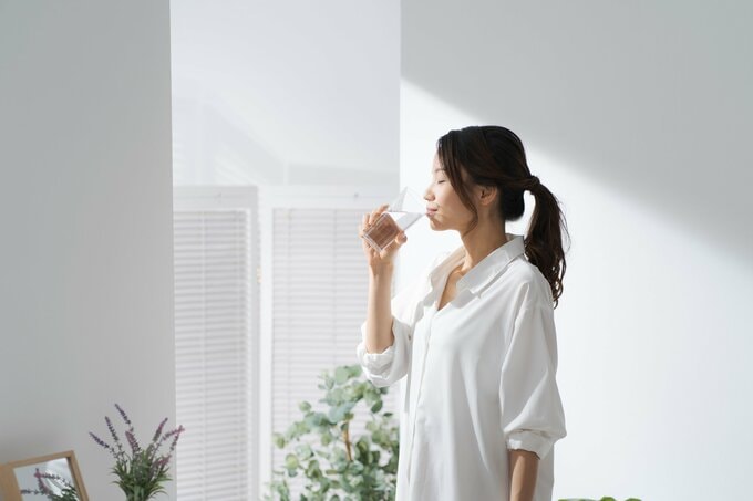 コップ一杯の水を飲む女性