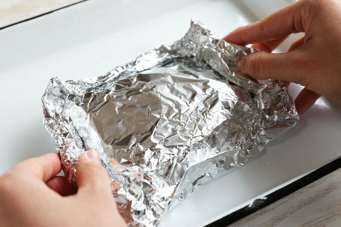 肉をアルミホイルで包む