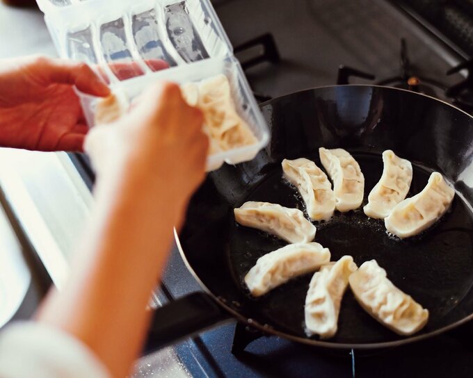 冷凍餃子をフライパンに入れる