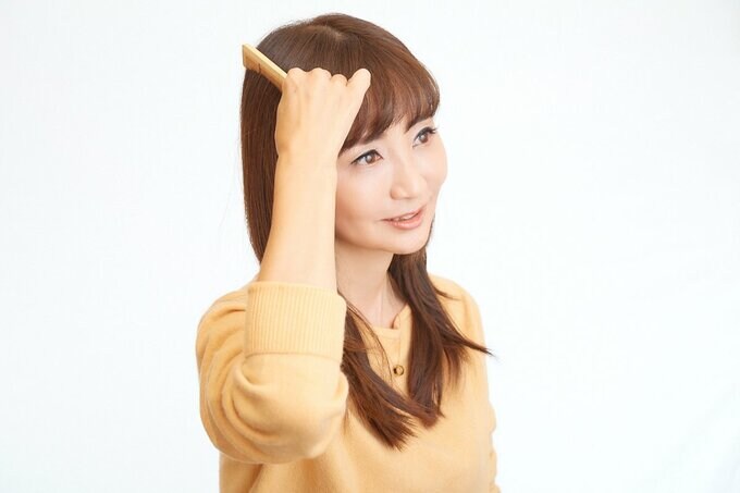 クシでかみをとく女性
