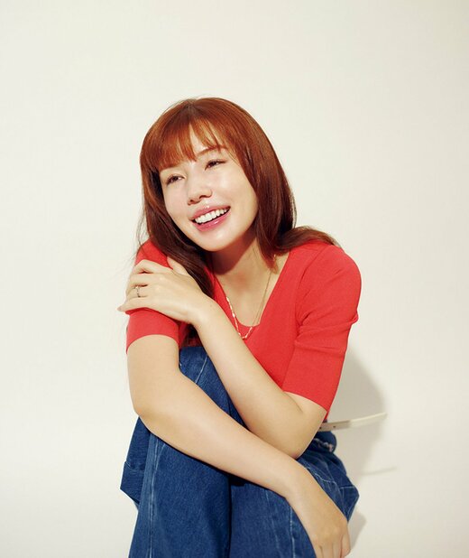 しゃがんで両腕を体の前に添えほほ笑む仲 里依紗さん