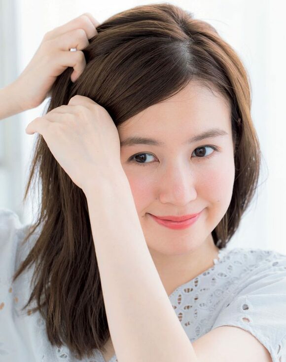 手グシでざっくりと髪を7対3に分ける様子
