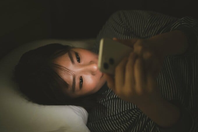 ベッドでスマホを見る子ども