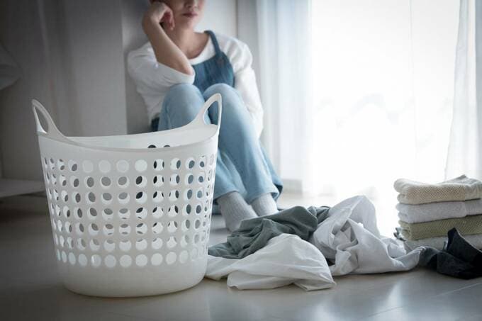 散乱している洗濯物と女性