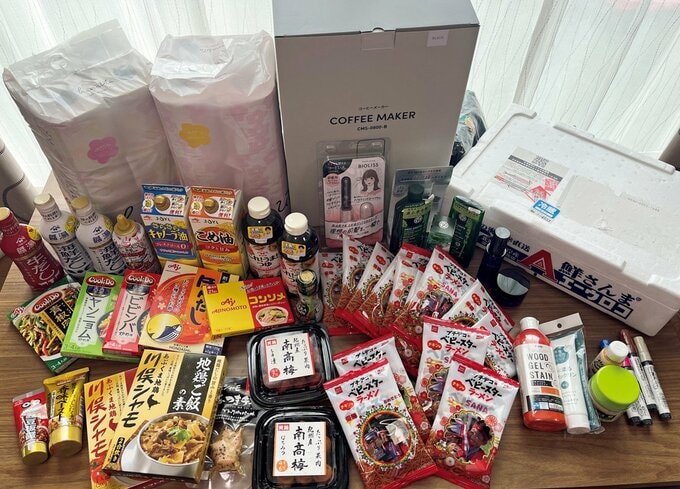 トイレットペーパーやコーヒーメーカーや食料品など、卓上にずらりと並ぶ当選グッズ