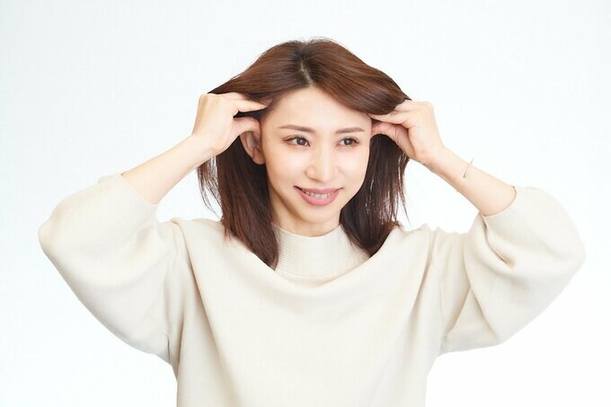 こめかみをマッサージする女性