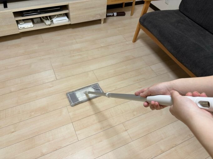 モップでフローリングの掃除をしている