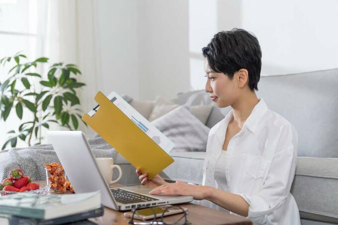 ファイルを見ながらパソコンを操作する女性