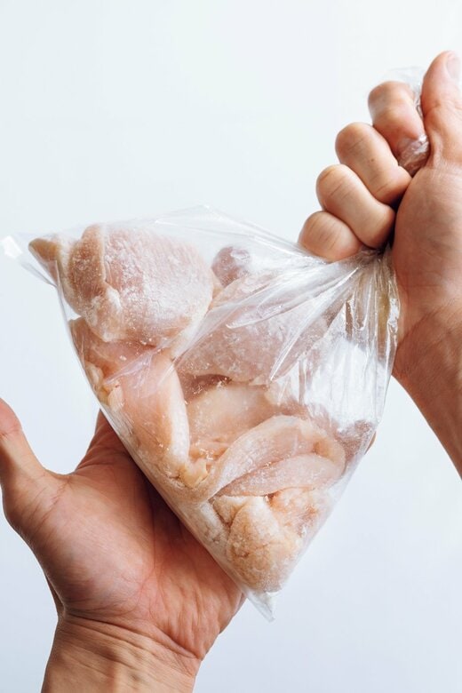 袋に入った鶏胸肉を揉む様子