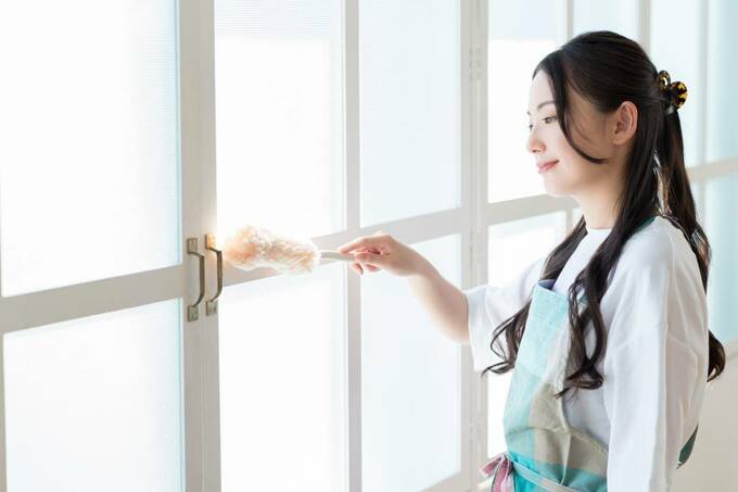 ハンディモップで掃除する女性