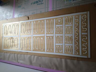 ボンド(床職人)を塗って、慎重に壁に貼りつけます