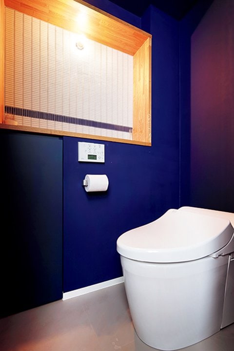 壁をシックなネイビーに塗装したトイレ