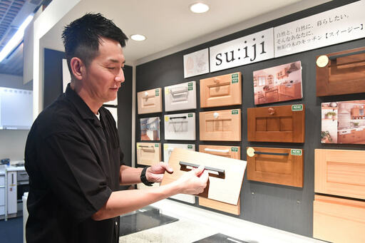 扉のサンプルを手にする男性