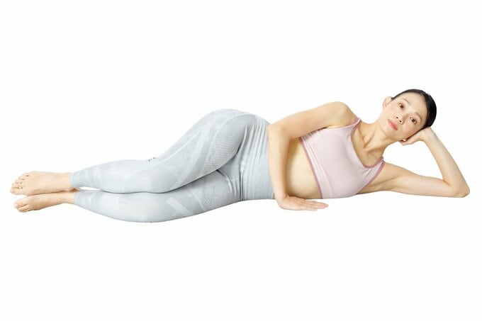 左ひじをついて床に横たわる女性