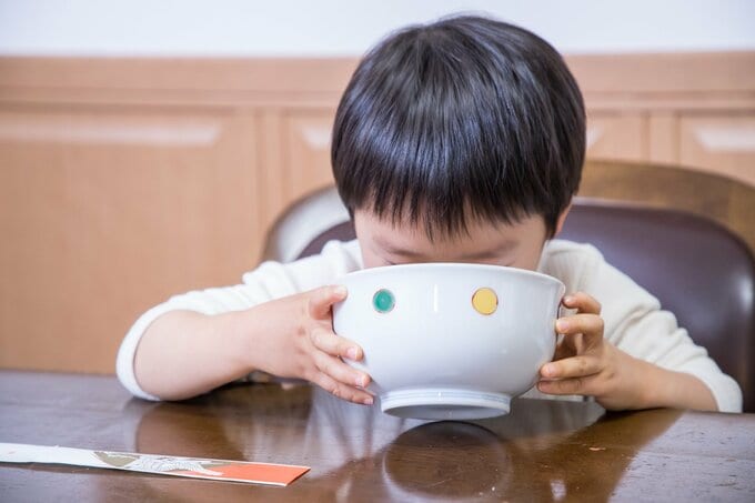 ラーメンの汁を飲む子供