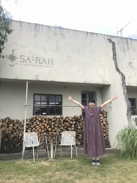 店の前で手を広げる女性