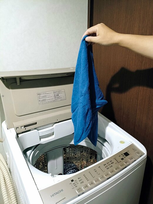 洗濯機にタオルを入れる様子