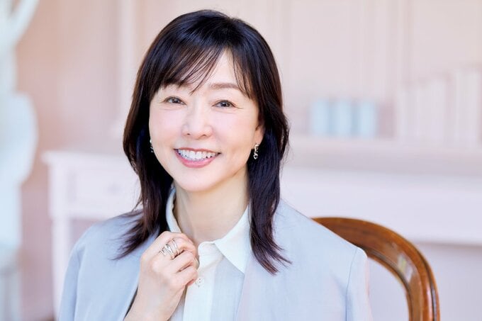 首元に手を添えほほ笑む女性
