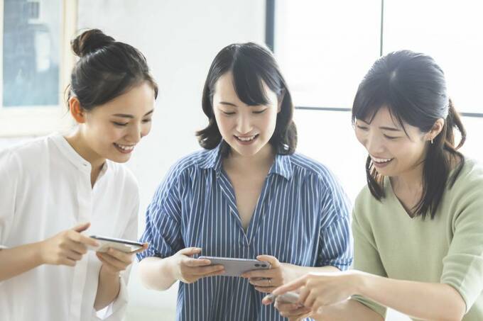 スマホを持つ女性3人