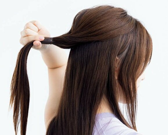 髪の毛を持ち上げる女性