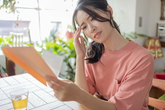 書類みて悩む女性