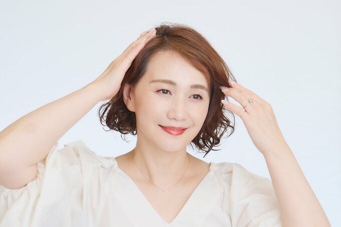 前髪を流す女性