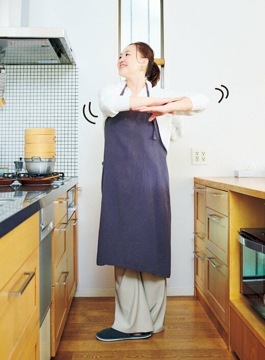 キッチンでストレッチをする女性