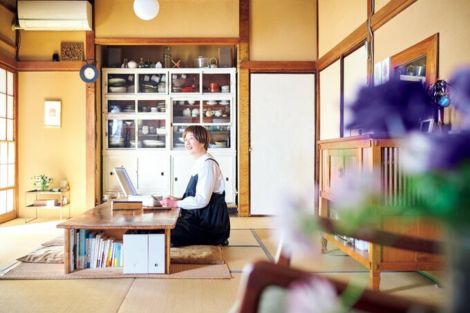 部屋にあるローテーブルの前に座る女性