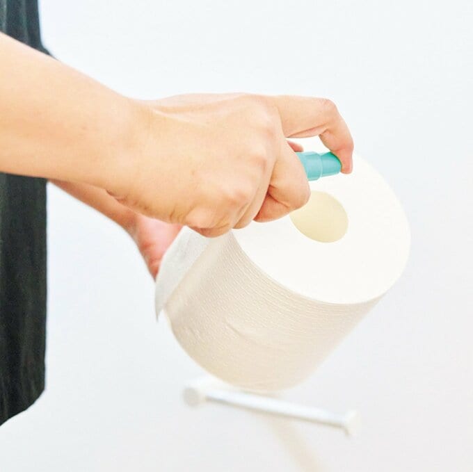 トイレットペーパーにスプレーを吹きかける手