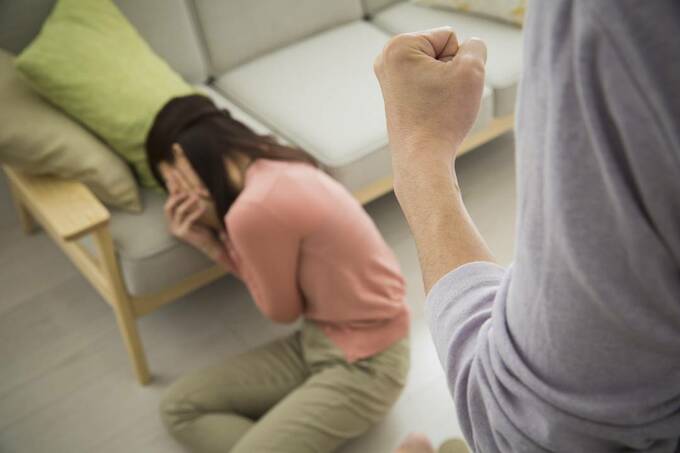 倒れる女性と拳を握る男性