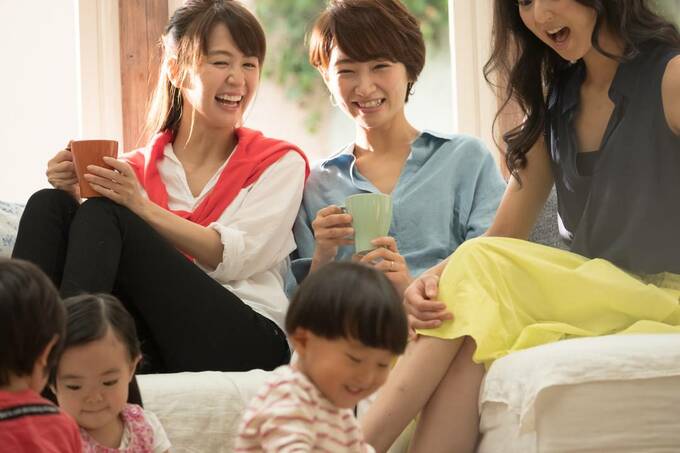 コップを持って話す女性