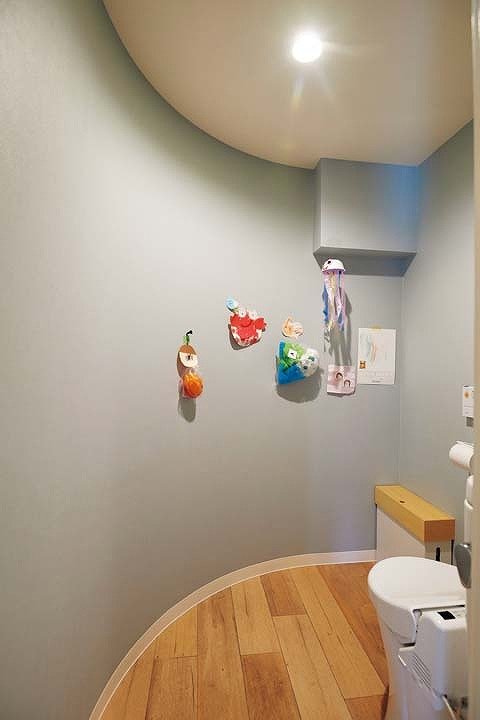 廊下のアール壁に沿って曲線を描くトイレ