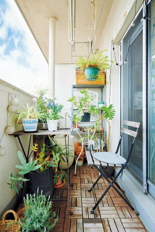 タイルを敷き詰め、たくさんの植物でレイアウトされたベランダ