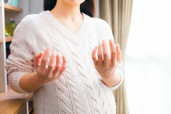 両手を胸の前に挙げている女性のイメージ画像