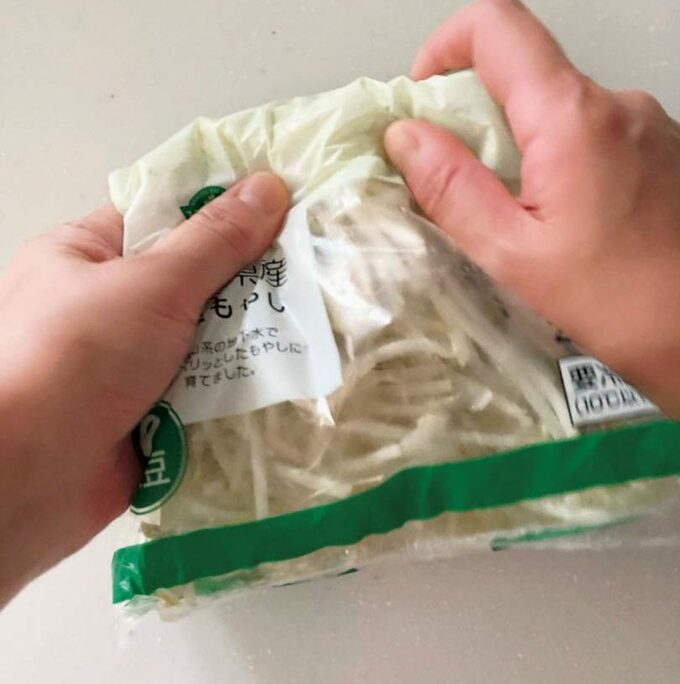 モヤシを袋の上から手でもむ
