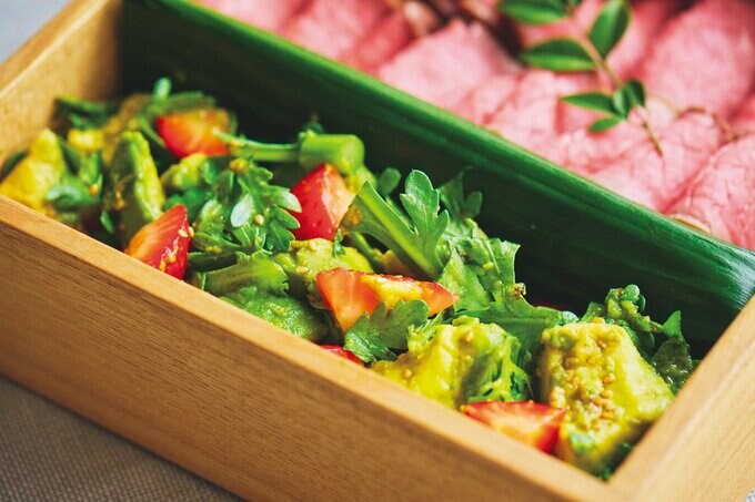 重箱のローストビーフ横に詰めた春菊とイチゴのあえもの