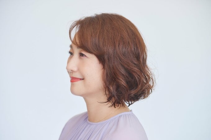 パーマヘアの女性の横顔