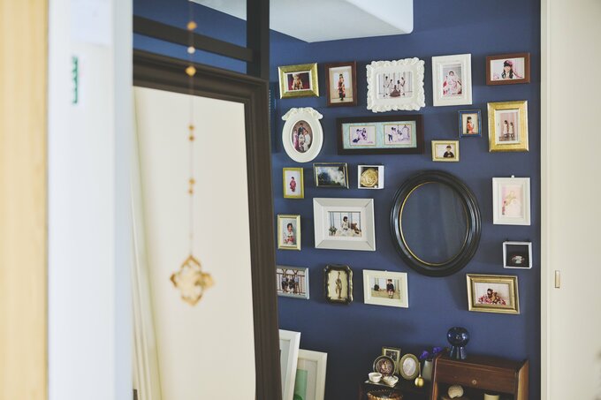紺色の壁紙に家族写真を並べ写真館風にした玄関