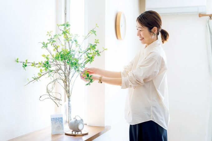 出窓に置かれた観葉植物を手入れする女性