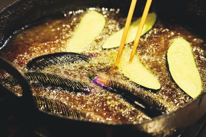 油でナスを揚げている様子