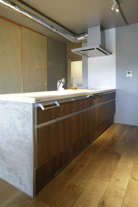 収納力のあるシステムキッチンをモルタルの腰壁でアレンジ
