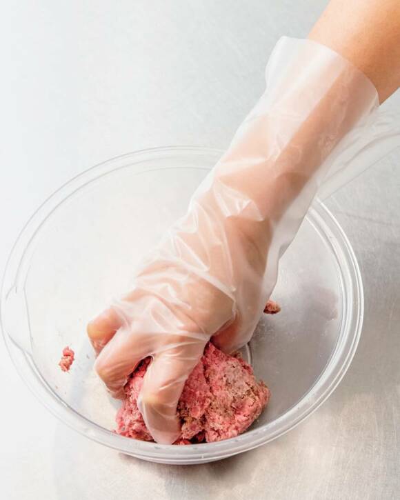 ポリ手袋をしてひき肉をこねる様子
