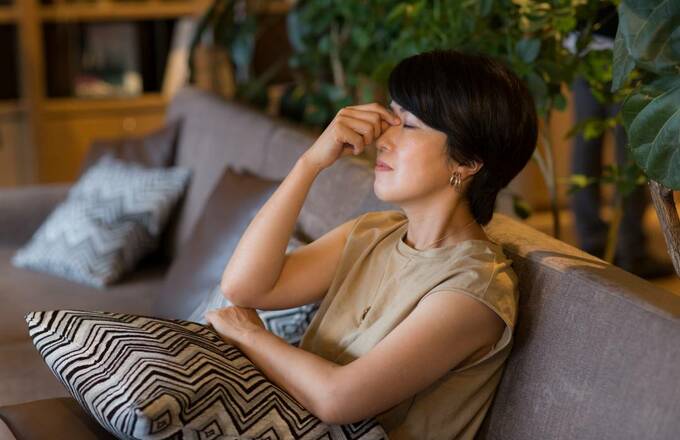 目頭をおさえる女性