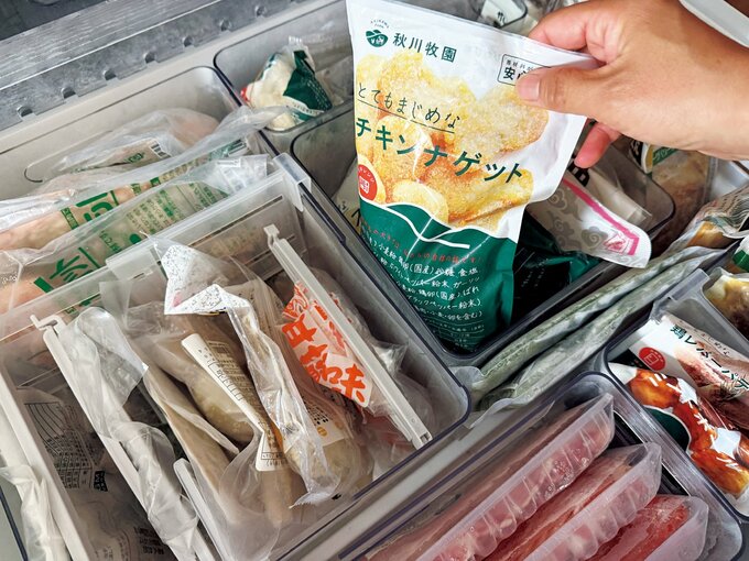 冷凍庫内の食品を持ち上げる手