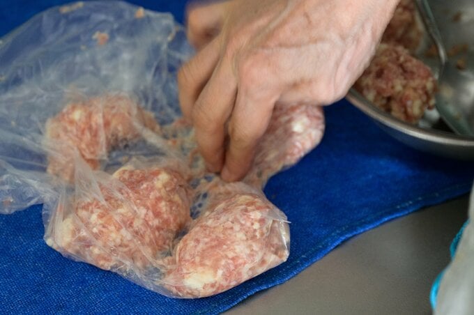 ポリ袋に肉ダネを入れている