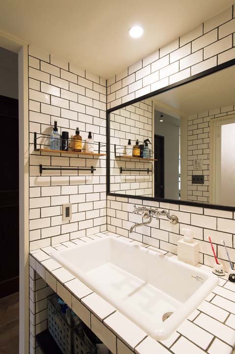 白いタイルと黒のパーツでシャープなイメージに仕上げた洗面室