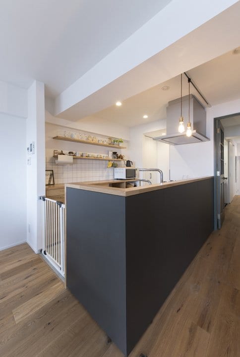 キッチンはマットな黒の腰壁をアクセントに