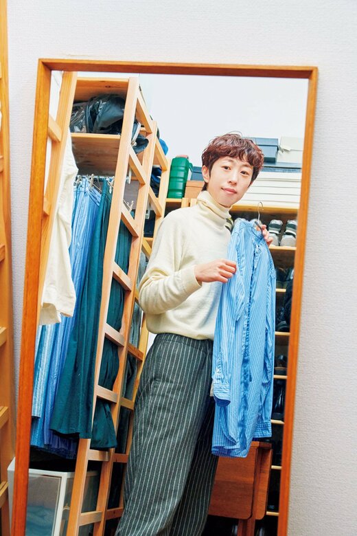 鏡を見ながら服を合わせている人